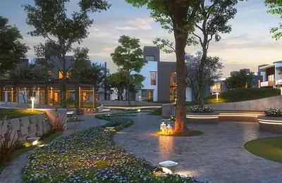 Landscaped courtyard lit at dusk with seating and flowering beds